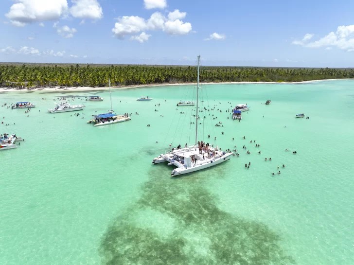 Boat and swimmers in the turquoise waters off Saona Island
